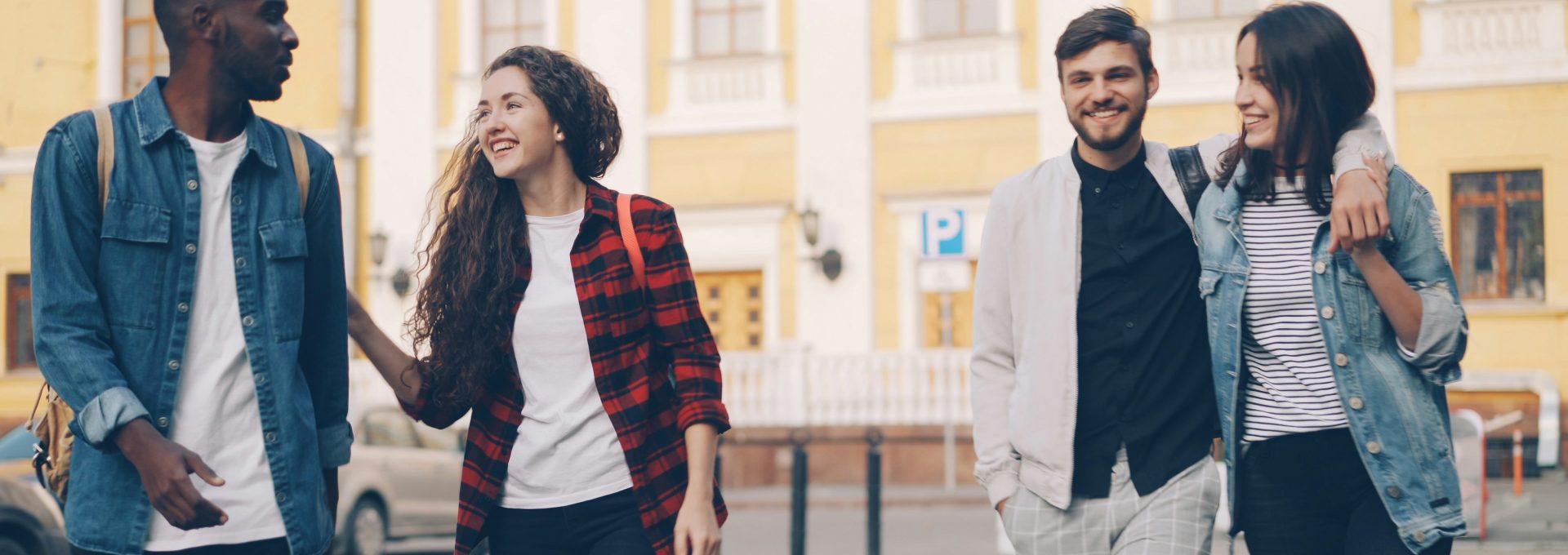 Friends are walking and smiling together outdoors.